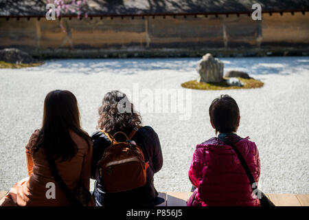 Japanische Touristen genießen Ruhe im Ryoanji-tempel in Kyoto, Japan. Dieser Zen buddhistische Tempel ist berühmt für seine rock garden. Stockfoto