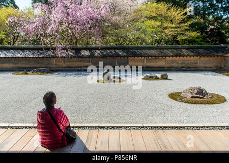 Japanische Touristen genießen Ruhe im Ryoanji-tempel in Kyoto, Japan. Dieser Zen buddhistische Tempel ist berühmt für seine rock garden. Stockfoto