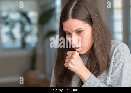 Junge schöne Frau zu Hause Unwohlsein und als Symptom für kalte oder Bronchitis Husten. Healthcare Konzept. Stockfoto