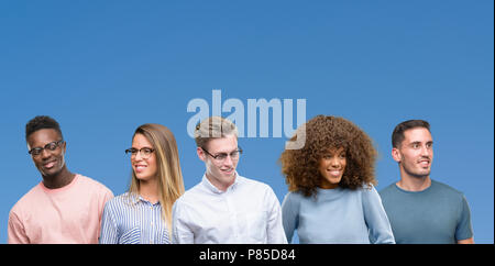 Zusammensetzung der Gruppe von Freunden über Blau blackground weg schauen mit einem Lächeln auf dem Gesicht zu Seite, natürlicher Ausdruck. Lachend zuversichtlich. Stockfoto