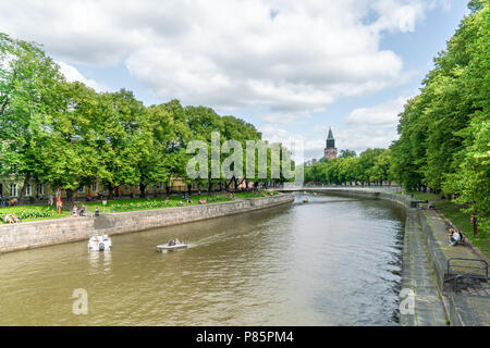 TURKU, FINNLAND - 8/7/2018: Boote auf dem Fluss Aura an sonnigen Sommertagen mit Turm von Turku Dom im Hintergrund Stockfoto