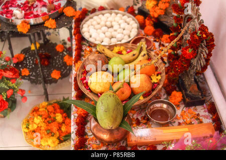 Hinduistische Puja, mit den Göttern. Weihrauch, Obst, Süßigkeiten, Rosenblüten, Ringelblumen Blumen, Statuen der Götter. Traditionelle, indische, Altar, Religion, Urlaub, Navratri, noch Leben. Stockfoto