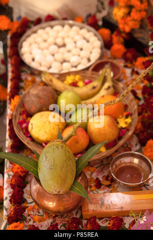 Hinduistische Puja, mit den Göttern. Weihrauch, Früchte, Kokos, Süßigkeiten, Rosenblüten, Ringelblumen Blumen, Statuen der Götter. Traditionelle, indische, Altar, Religion, Urlaub, Navratri, noch Leben. Stockfoto