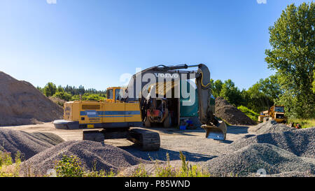 Bewegliche Bagger in der Mitte der große Stapel von Bau Aggregat Stockfoto