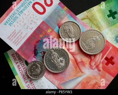 Schweizer Münzen und Geldscheine auf dunklem Hintergrund. Währung in der Schweiz und Liechtenstein verwendet. Stockfoto