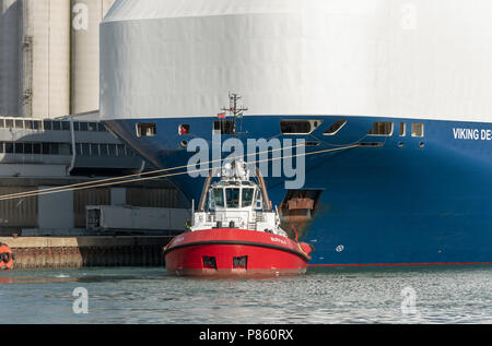 Schlepper neben der Viking Schicksal ein Car carrier Schiff. Hafen von Southampton, England UK. Stockfoto