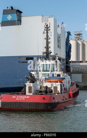 Schlepper neben der Viking Schicksal ein Car carrier Schiff. Hafen von Southampton, England UK. Stockfoto