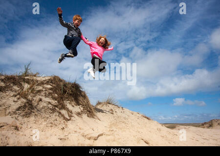 Springen die Kinder in den Dünen auf Texel, Niederlande Stockfoto