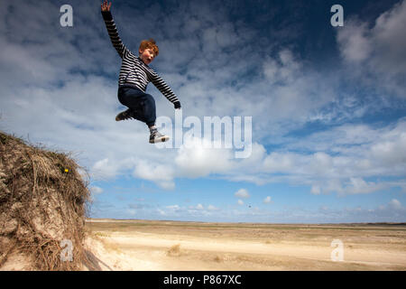 Springen die Kinder in den Dünen auf Texel, Niederlande Stockfoto