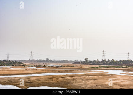 Indian River mit sauberem Wasser in sandigen Bett mit Power Grid Kabelverlegung Hintergrund. Stockfoto