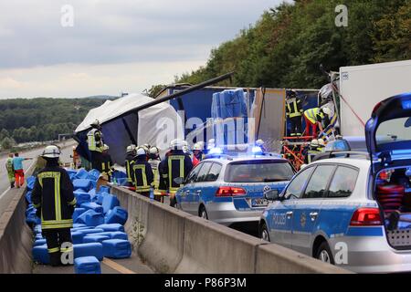 Hagen, Deutschland. 09 Juli, 2018. Fahrzeuge der Polizei und Feuerwehr stand an der Unfallstelle nach einem schweren LKW-Unfall auf der Autobahn A1 in der Nähe von Hagen. Vier Lkw hit das Ende einer Autobahn Stau, so ein Sprecher der Polizei Dortmund. Ein Mann starb, ein weiterer wurde schwer verletzt. Der Verkehr auf der A1 wurde für mehrere Stunden gesperrt. Credit: Alex Talash/dpa/Alamy leben Nachrichten Stockfoto