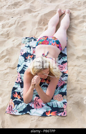 Bournemouth, Dorset, Großbritannien. 10. Juli 2018. UK Wetter: Nach einem bewölkten starten, ein anderes heißen, sonnigen Tag. Modell Leanne Kabel genießt den Sonnenschein an Alum Chine Beach. Credit: Carolyn Jenkins/Alamy leben Nachrichten Stockfoto