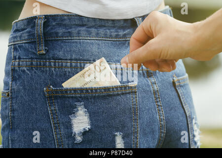 Diebstahl von Geld aus der Gesäßtasche der Jeans, close-ups Stockfoto