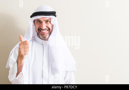 Senior arabischen Mann mit grosses Lächeln tun ok Zeichen, Daumen hoch, mit den Fingern glücklich, ausgezeichnete Zeichen Stockfoto