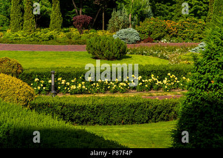 Blumen und Blüten sowie Betten und Pfade mit Bäumen Stockfoto