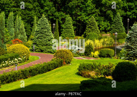 Blumen und Blüten sowie Betten und Pfade mit Bäumen Stockfoto