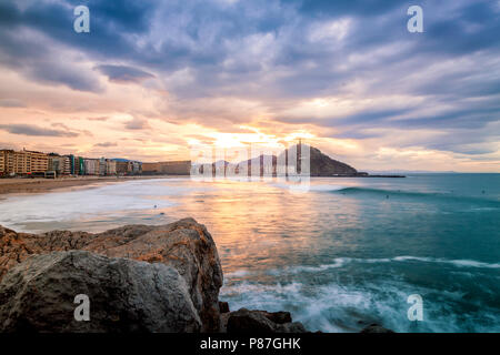 Toller Sonnenuntergang über La Zurriola Strand, mit den Sonnenuntergang hinter Monte Urgull Stockfoto