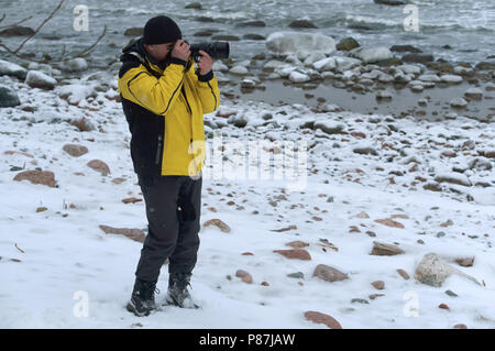 Fotografieren im Winter, der Fotograf nahm seine Handschuhe aus, der Fotograf auf der Straße in der Kälte Stockfoto