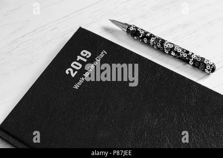 Ein 2019 Schreibtisch Tagebuch mit einem Stift. Stockfoto