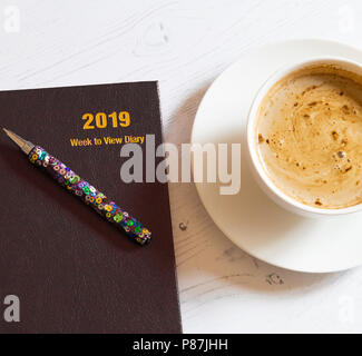 Ein 2019 Schreibtisch Molkerei mit einer Tasse Kaffee neben. Stockfoto