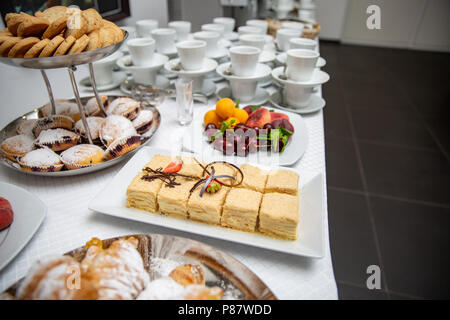 Napoleon Kuchen mit Erdbeeren und Schokolade dekoriert. Croissants, Muffins und Früchte auf einem Buffet. Dessert Tabelle Stockfoto