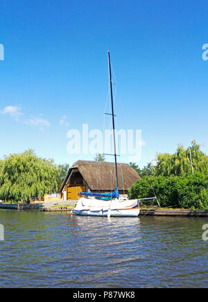 Ein reetgedecktes Bootshaus und günstig chartern Yachtcharter auf dem Fluss Bure auf der Norfolk Broads in Horning, Norfolk, England, Vereinigtes Königreich, Europa. Stockfoto