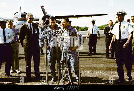 Astronauten John W. Young (links), Pilot; I. und Virgil Grissom, Befehl Pilot, stehen an Mikrofone bei Skid Streifen des Kap nach von der Recovery Schiff geflogen, USS Intrepid Stockfoto