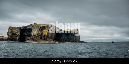 Panoramablick auf Staffa Insel und Boot vor der Küste Schottlands, Stockfoto
