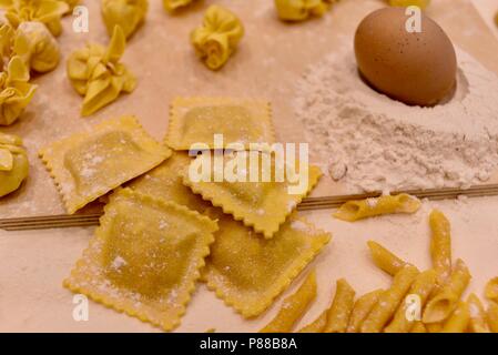 Vielfältige Auswahl an handgefertigten, traditionelle italienische Raw (Ungekocht) pasta auf Tabelle, die mit Ei, Mehl, Salz und Wasser. Stockfoto