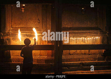 Kind Beleuchtung Kerze in der Kirche des Heiligen Grabes, Jerusalem, Israel Stockfoto