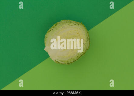 Frische grüne Kohl auf einem Hintergrund von ähnlichen (analog Farben) Schattierungen von Grün. Zwei Ton farbe Papier. Abstrakte Foto. Vorlage. Ansicht von Oben. Stockfoto