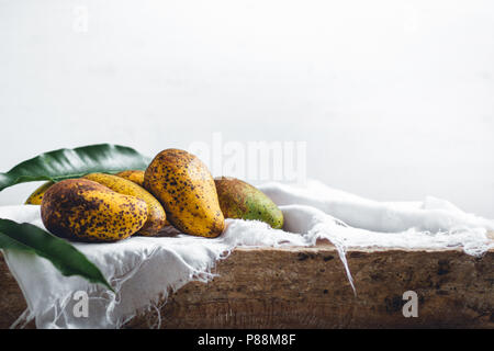 Natur mango auf einer hölzernen Platte und mit einem weißen Tuch Stockfoto