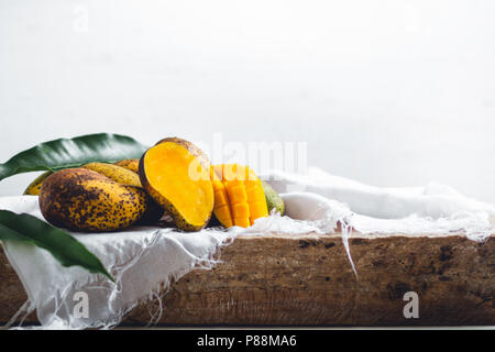 Natur mango auf einer hölzernen Platte und mit einem weißen Tuch Stockfoto