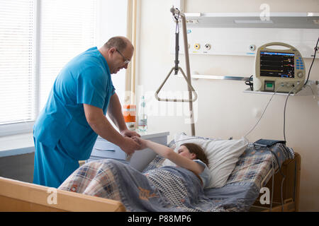 Belarus, Gomel, 24. April 2018. Gomel Central Hospital. Arzt am Bett des Patienten. Der Arzt im Gespräch mit dem Patienten im Krankenhaus Zimmer Stockfoto