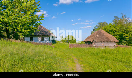 Authentische Holzhaus mit Schilf im Hof unter dem blauen Himmel bedeckt. Für ihr Design Stockfoto