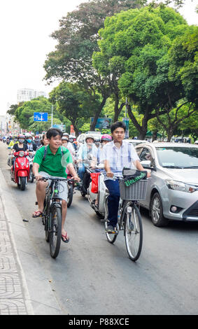 Radfahrer und Motorradfahrer in den Berufsverkehr in Ho Chi Minh City, Vietnam. Stockfoto