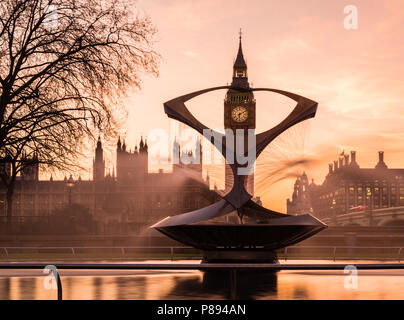 Orange Sonnenuntergang über den Big Ben und die Houses of Parliament in London, einschließlich die Westminster Bridge und eine Statue und Brunnen im St. Thomas hospital Gärten Stockfoto