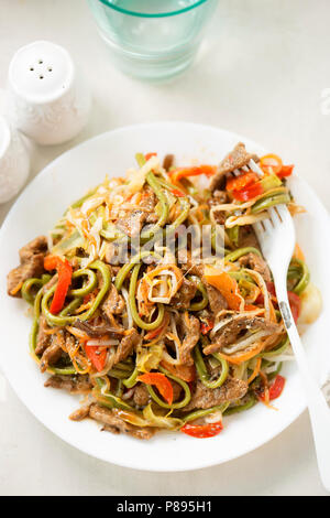 Chili Rindfleisch Nudeln. Wok gebratenes Rindfleisch im Tamarind & Soja Sauce mit grünen Nudeln, Sojasprossen, Karotten und rote Paprika Stockfoto