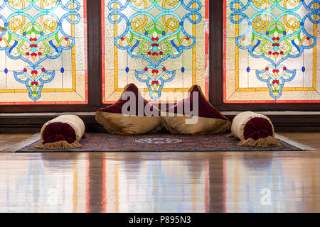 Alte Karawansereien oder Könige Inneneinrichtung mit Netzwerk ornamentalen Fenster, Teppiche und Kissen mit traditionellen Artefakten. Stockfoto