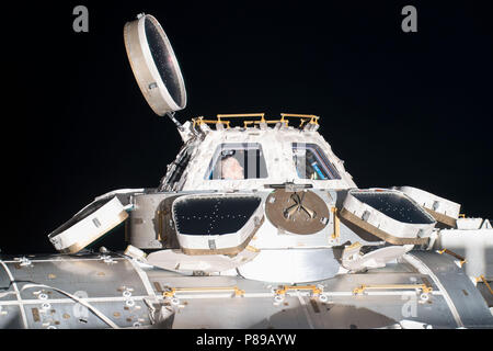 NASA-Astronaut Ricky Arnold blickt aus den sieben-windowed Kuppel, die Ansichten der Erde unten sowie nähern und Nachschub abfliegende Schiffe an Bord der Internationalen Raumstation am 30. Juni 2018 in der Erdumlaufbahn. Stockfoto