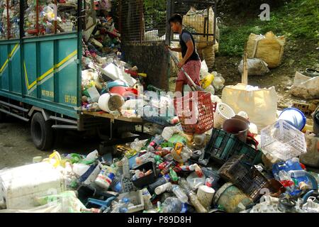 ANGONO, Rizal, Philippinen - 4. JULI 2018: Ein Arbeiter an einem Materialien Verwertungsanlage neu entladen geliefert, Kunststoff materialien für die Sortierung und die Seg Stockfoto