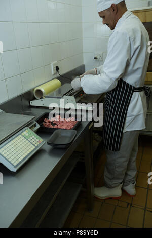 Metzger verpacken Hackfleisch in Metzgerei Stockfoto