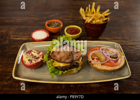 Fleisch Burger mit Pommes frites auf hölzernen Tisch Stockfoto