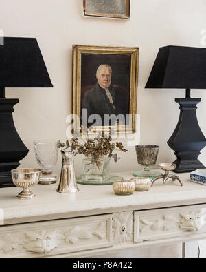 Paar schwarzer passende Lampen mit getrockneten Blumen und Besteck Stockfoto