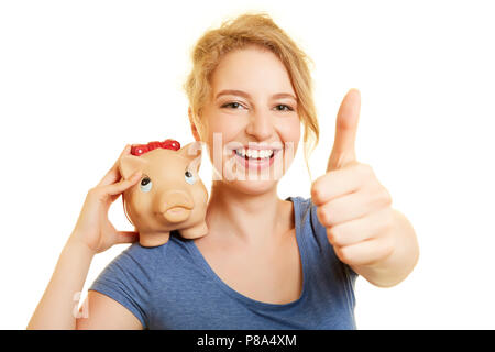 Junge Frau mit piggy Bank gibt Zustimmung zu Investitionen mit einem Daumen hoch Stockfoto