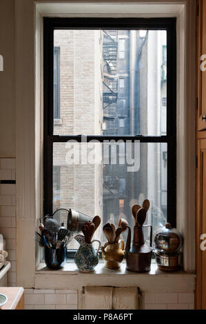 Kochutensilien in einer Zusammenstellung der Krüge und Töpfe entlang einer New Yorker Wohnung fensterbänke gespeichert Stockfoto