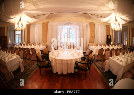 Platz Layout einer Hochzeit Braut mit dem runden Tisch in der Mitte eines kolonialen Raum mit weißen transparente Decke Vorhängen, weißen Tischdecken und ... Stockfoto