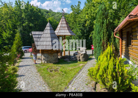 Ein Holzhaus mit einem Brunnen im Innenhof mit Blick auf einen Stein in der Mitte des Waldes. Das Auto Besucher kamen. Für ihr Design Stockfoto