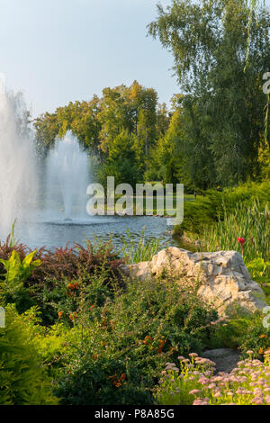 Eine malerische Form der Stein lag in einem Bett von schönen Blumen am Ufer eines kleinen Teich mit Springbrunnen. . Für ihr Design Stockfoto