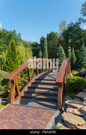 Hölzerne Brücke im Park mit schönen Landschaft Gestaltung von Nadel- und Laubbäume Plantagen. Für ihr Design Stockfoto